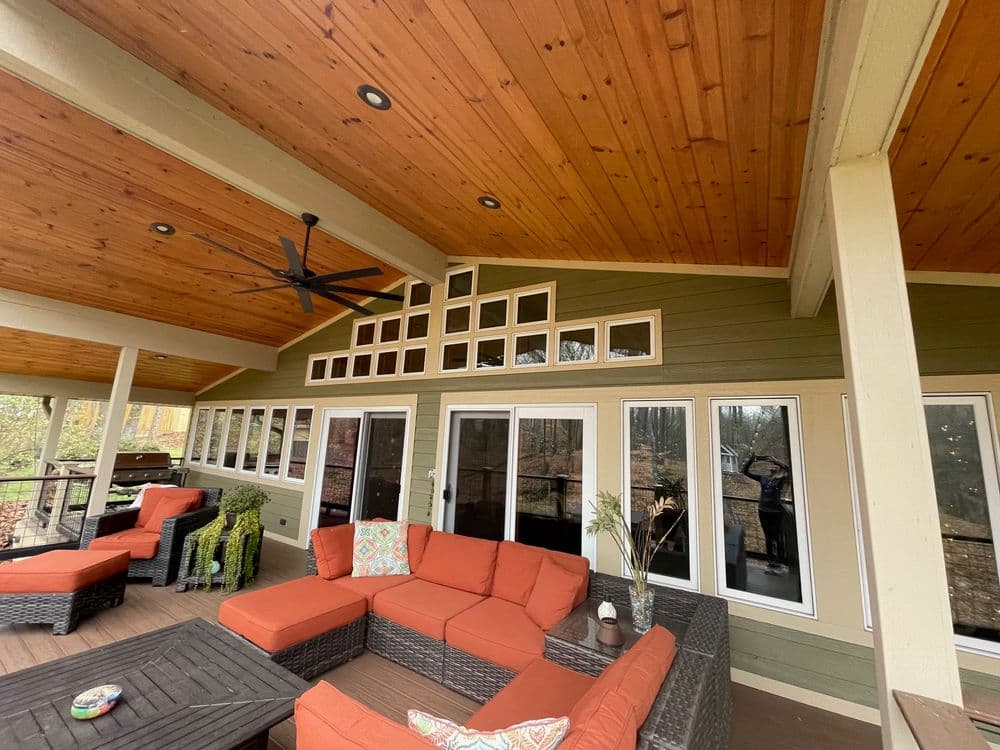 Spacious outdoor living area with orange seating and wooden ceiling design.