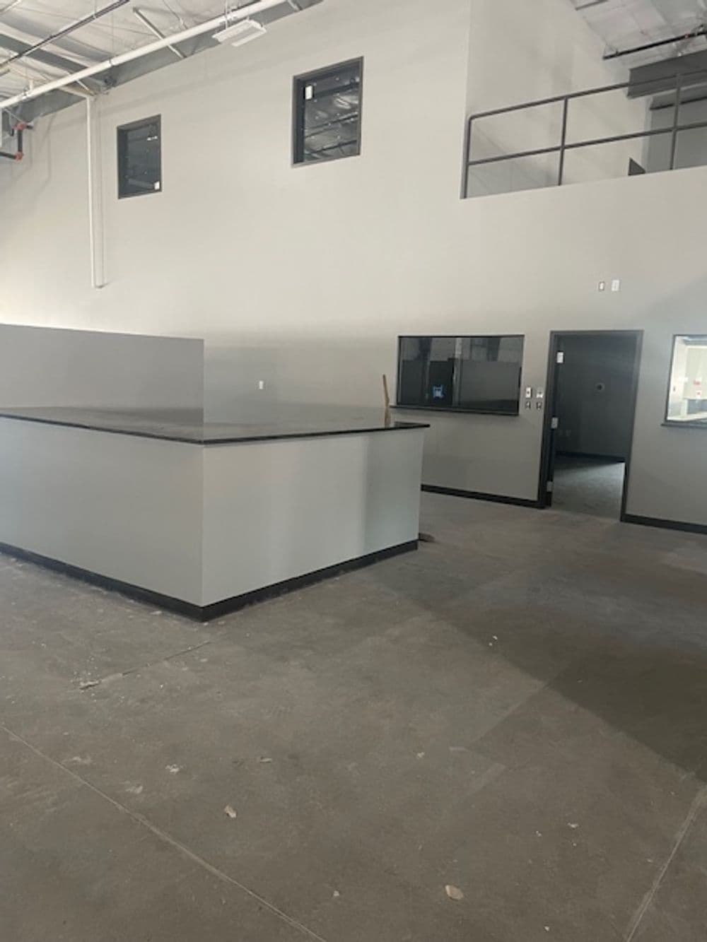 Empty industrial space featuring gray walls and a reception counter.