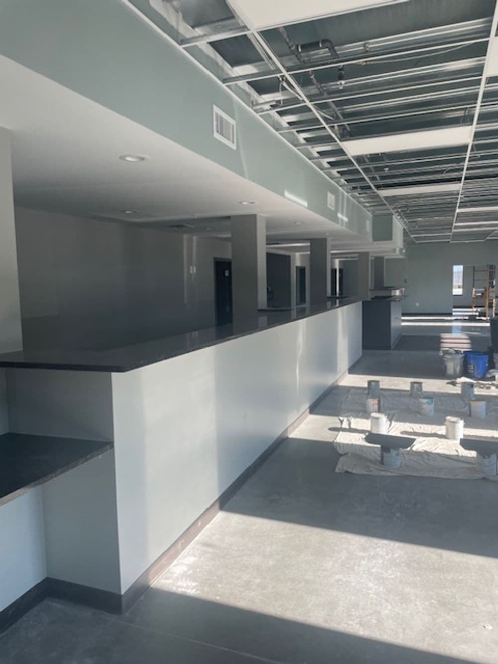 Renovated commercial interior with gray walls, open space, and a long counter.