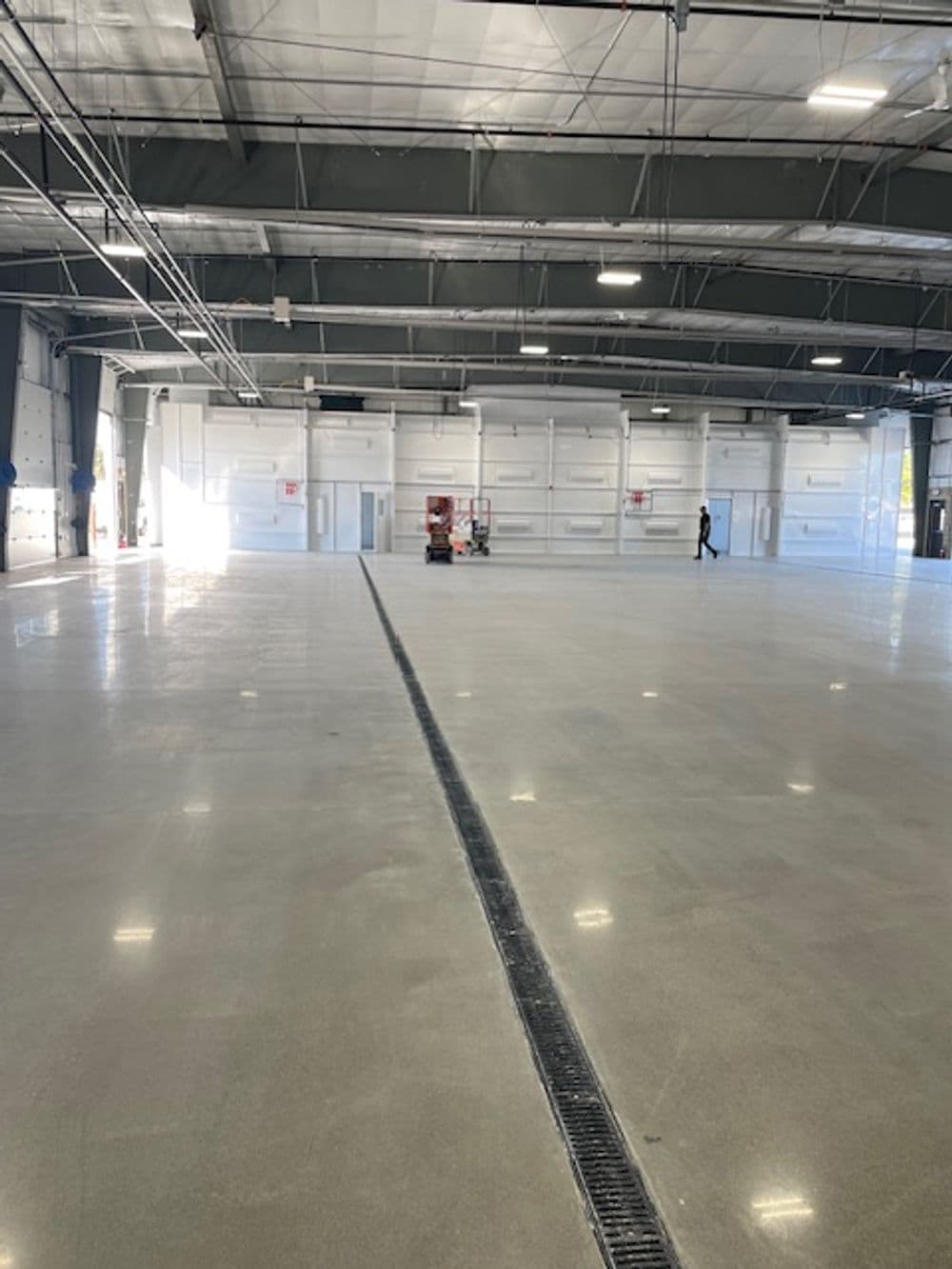 Spacious industrial warehouse interior with polished concrete floor and large bay doors.