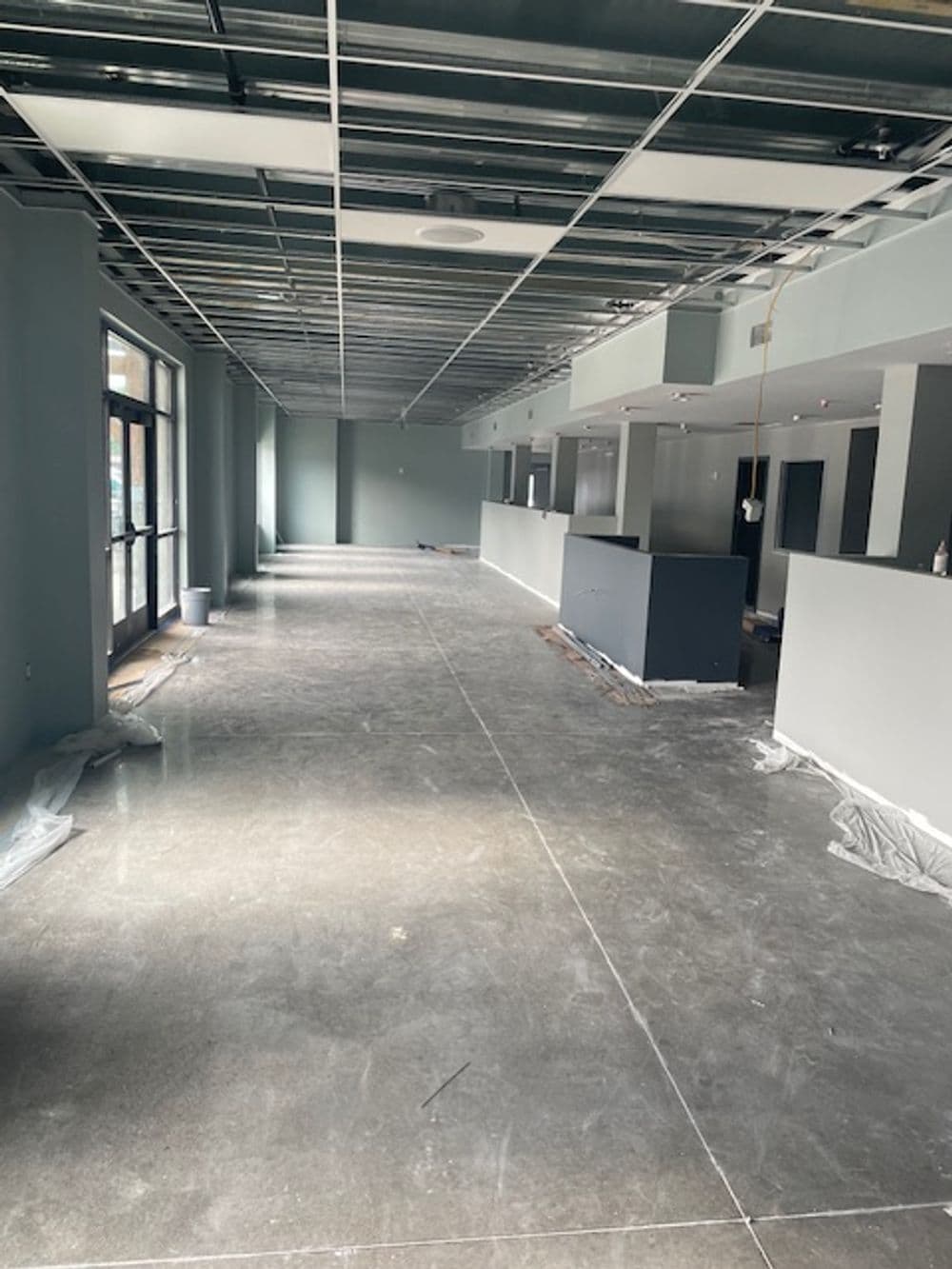 Empty commercial space featuring polished concrete floors and fresh, light blue walls.